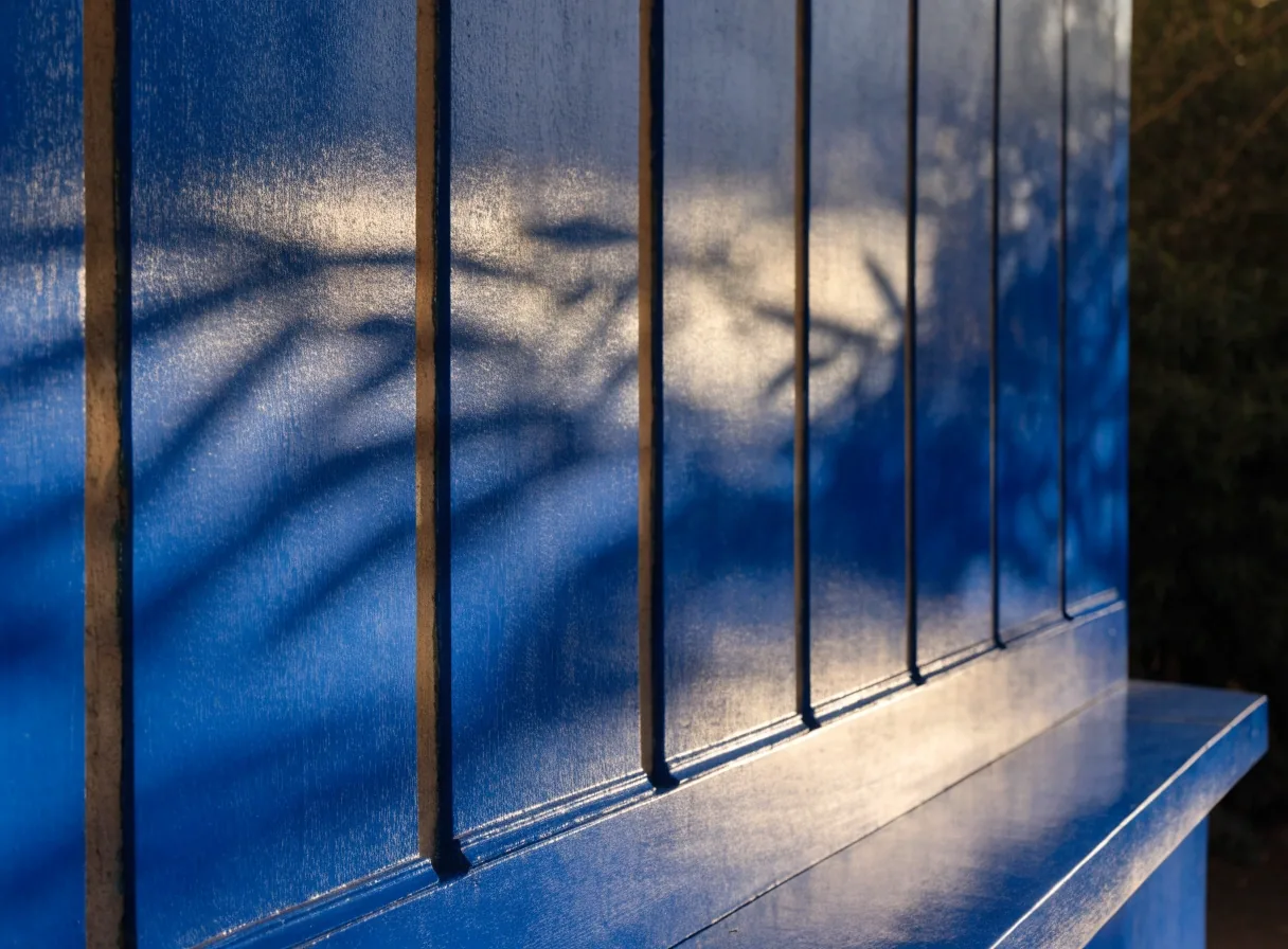 Mur bleu du Jardin Majorelle traversé par une ombre de bambou